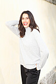 Long-haired young woman in white turtleneck jumper, laughing, red lipstick