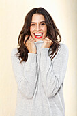 Long-haired young woman in white turtleneck jumper, laughing, red lipstick