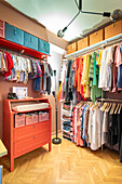 Walk-in wardrobe with colourful clothes and storage boxes