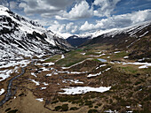 Berglandschaft mit schmelzendem Schnee und Bergbach, Flüelatal, Graubünden, Schweiz