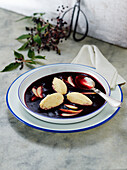 Lilac berry soup with semolina dumplings and apple slices