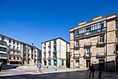 Soria, Spain, Aug 13 2009, A wide shot of a plaza in Soria, Spain, with several people walking around. The plaza is surrounded by buildings, some of which have balconies