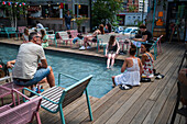 Clients refresh by the pool at Manifesto Market, a must-visit cultural experience in the heart of Prague with pop-up design retail experience bars and high-quality street food.