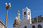 Cabildo with the clock tower of the Legislative Palace of the Autonomous City of Buenos Aires, Argentina behind. The Cabildo was the town hall or seat of government in colonial times.