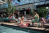 Clients refresh by the pool at Manifesto Market, a must-visit cultural experience in the heart of Prague with pop-up design retail experience bars and high-quality street food.