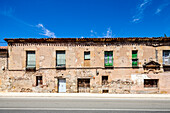 A row of old, stone houses in Soria, Spain, with windows and doors.