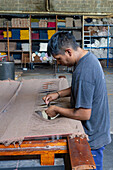 A worker ties the yarn by hand to make tassels at Hilandería Warmi, a weaving mill in Palpalá, Argentina.