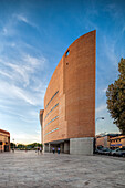 Seville, Spain, Sep 30 2009, A sleek contemporary building stands tall in Seville, Spain, surrounded by beautiful evening light as people stroll by in the plaza.