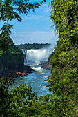 Iguazu Falls National Park in Argentina at right with Brazil at left. A UNESCO World Heritage Site. Pictured is the Devil's Throat or Garganta del Diablo, the largest of the falls at Iguazu and the border between the two countries runs through this waterfall.