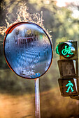 Morning dew evaporates on a convex mirror next to a traffic light in Sevilla, Andalucia, Spain, creating a unique visual effect.