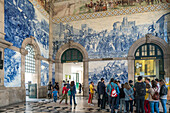 Porto, Portugal, Apr 15 2017, Tourists admire the stunning azulejos at Sao Bento Station in Porto, Portugal. This iconic artwork beautifully depicts historical scenes and is a must-see for visitors.