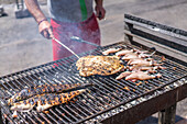 A vibrant outdoor barbecue at a restaurant in Matosinhos, Porto, Portugal, featuring fresh seafood being grilled to perfection.