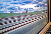 Scenic view through the window of a high-speed AVE train racing through Cordoba, Andalusia, Spain. Captures the dynamic movement and picturesque landscape.