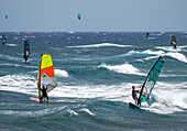 Windsurfers tackle the waves during the World Championship in El Medano, Tenerife, Spain, showcasing their skills and excitement in August 2024.