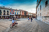 Burgo de Osma, Spain, Aug 12 2009, Visitors stroll and cycle through Cathedral Square in El Burgo de Osma, enjoying the vibrant atmosphere as night approaches.