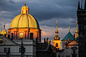 View of St. Francis of Assisi Church and city skyline at sunset from Charles Bridge in Prague