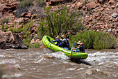 Paddlers in a small raft in White's Rapid on the Colorado River near Moab, Utah.