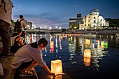 People float lanterns on the river, in front of Atomic Bomb Dome with floating lamps on Motoyasu-gawa River during Peace Memorial Ceremony every August 6 in Hiroshima, Japan