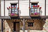 A typical house in Yanguas features colorful flower boxes that enhance its rustic charm, showcasing the architectural beauty of Soria, Spain.