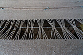 Yarn tied by hand to make tassels when the fabric is cut at Hilandería Warmi, a weaving mill in Palpalá, Argentina.