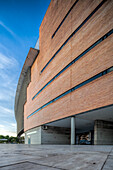 A contemporary building with striking lines and textures is showcased against a clear sky in scenic Seville, Spain.