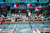 Clients refresh by the pool at Manifesto Market, a must-visit cultural experience in the heart of Prague with pop-up design retail experience bars and high-quality street food.