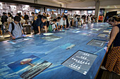 People exploring museum materials. Exhibition inside the Hiroshima Peace Memorial Museum, Hiroshima, Japan