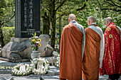 Monks praying in front of Cenotaph for Korean Victims in the Hiroshima Peace Memorial Park, Hiroshima, Japan