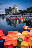 People float lanterns on the river, in front of Atomic Bomb Dome with floating lamps on Motoyasu-gawa River during Peace Memorial Ceremony every August 6 in Hiroshima, Japan