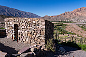 Partially reconstructed ruins in the Pucara of Tilcara, a pre-Hispanic archeological site near Tilcara, Humahuaca Valley, Argentina. The town of Sumaj Pacha Alto is across the valley.