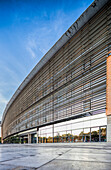 The NH Plaza de Armas hotel showcases contemporary architecture with a sleek design against a clear blue sky in Seville.