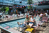 Clients refresh by the pool at Manifesto Market, a must-visit cultural experience in the heart of Prague with pop-up design retail experience bars and high-quality street food.