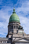 A bronze quadriga statue in front of the dome of the Argentine National Congress Building in Buenos Aires, Argentina.