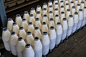 Large bobbins of sheep's wool yarn for blending with llama wool at Hilandería Warmi, a weaving mill in Palpalá, Argentina.