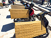 Folded cardboard protects the seats of parked motorcycles outside a shopping center in Tartagal, Argentina.