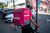 Young delivery boy on a bike working for Foodora in Prague, Czech Republic