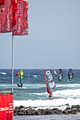 Dynamic windsurfing championship banners wave in the breeze at El Medano, Tenerife, Spain in August 2024, capturing the thrilling energy of the event.