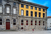 Porto, Portugal, Apr 15 2017, Boys enjoying football outside historic Centro Portugues da Fotografia, Porto, Portugal.