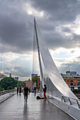 A musician plays on the La Puente de la Mujer or the Woman's Bridge over Dock 3 in Puerto Madero, Buenos Aires, Argentina.