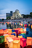 People float lanterns on the river, in front of Atomic Bomb Dome with floating lamps on Motoyasu-gawa River during Peace Memorial Ceremony every August 6 in Hiroshima, Japan