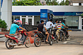 Motorcyclists wait in line to refuel at a service station in Tartagal, Argentina.