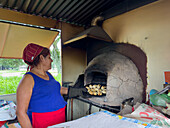 A woman bakes traditional empanadas in a clay oven in San Salvador de Jujuy, Argentina.