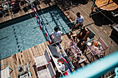 Clients refresh by the pool at Manifesto Market, a must-visit cultural experience in the heart of Prague with pop-up design retail experience bars and high-quality street food.