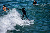 Surfers in Grande Plage beach of Biarritz, France