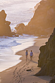 Couple walking on the beach in front of Finca Barlovento at sunset, Tayrona National Park, Colombia