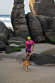 Kid walking his dog on the beach in front of Finca Barlovento, Tayrona National Park, Colombia