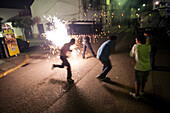 Participants flee from the firecracker-covered bull in a festive Aznalcázar celebration, blending tradition and excitement.