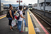 Menschen warten auf dem Bahnsteig auf den Zug, Kyoto