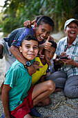 Group of playful local kids having fun with a foreigner woman, Santa Marta, Colombia