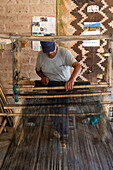 A man weaving on a wooden foot loom in Seclantas, Argentina in the Calchaqui Valley.